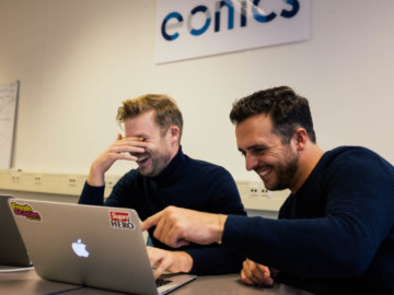 Sfeerbeeld van lachende mannen achter laptop